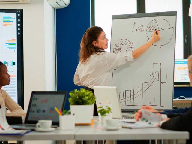 Focused team leader presenting marketing plan to interested multiracial coworkers